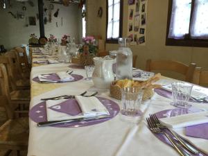 una mesa con platos y utensilios púrpura y blanco en La Prediletta, en Motta di Livenza