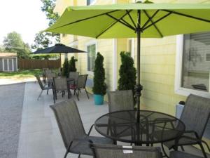 a patio with a table and chairs and an umbrella at Ahoy Inn Guesthouse in Put-in-Bay