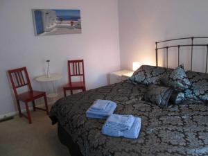 1 dormitorio con 1 cama, 2 sillas y mesa en Ahoy Inn Guesthouse en Put-in-Bay