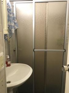 a shower with a glass door next to a sink at Villaggio Riviera in Punta del Este