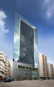 un edificio alto con ventanas de cristal en una ciudad en iclub To Kwa Wan Hotel en Hong Kong