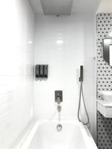 La salle de bains blanche est pourvue d'une baignoire et d'un lavabo. dans l'établissement Stay in Style at Nimman R306AB, à Chiang Mai