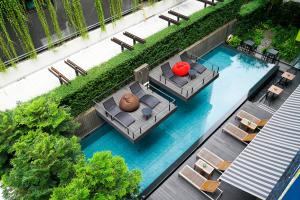 uma vista superior de uma piscina com cadeiras e mesas em LiT BANGKOK Residence em Bangkok