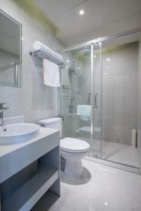 a bathroom with a toilet and a shower and a sink at Metropolo Jinjiang Shenyang Country Garden Datong Lake Subway Station in Shenyang