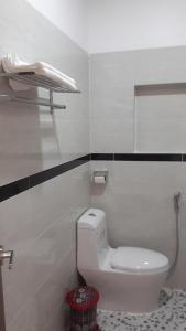 uma casa de banho com WC e um telefone na parede em Motel Hoang Gia em Long Khanh