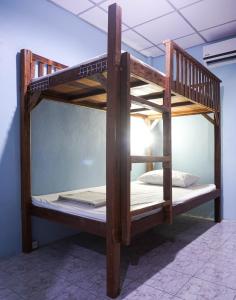 ein Etagenbett aus Holz in einem Zimmer in der Unterkunft Zleep63 in Bangkok