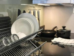 a drying rack with plates and pans in a kitchen at Stay in Style at Nimman R201 in Chiang Mai