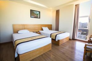 Habitación de hotel con 2 camas y ventana en Nhat Linh hotel & Apartment, en Da Nang