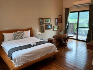 ein Schlafzimmer mit einem großen Bett und Holzboden in der Unterkunft Fuli Stay 無提供早餐的住宿 in Fuli