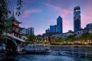 une ligne d'horizon de la ville au crépuscule avec une rivière et des bâtiments dans l'établissement Sofitel Guiyang Hunter, à Guiyang