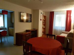 a living room with a red table and a couch at Appartamenti Osti Sansoni Mariarosa in Andalo