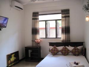 a bedroom with a bed and a window at Miheen Hotel & Resort - Anuradhapura in Mihintale