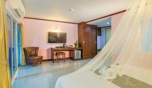 a bedroom with a bed and a desk with a chair at Aonang Silver Orchid Resort in Ao Nang Beach