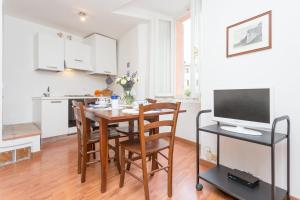 una cucina e una sala da pranzo con tavolo e TV di Appartamento Historical Center Perugia a Perugia