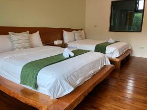 2 Betten mit grüner und weißer Bettwäsche in einem Zimmer in der Unterkunft Fuli Stay 無提供早餐的住宿 in Fuli