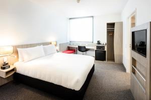 a hotel room with a bed and a television at Ibis Mackay in Mackay