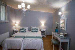 a bedroom with a bed and a desk and a bed sidx sidx sidx at Liostasi Maison Provencale in Argostoli