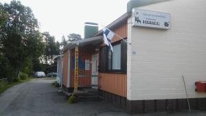 a building with a sign on the side of it at Matkustajakoti Kuutamo Guesthouse in Suomussalmi