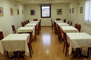 uma fila de mesas e cadeiras num quarto em Hotel Agorreta em Salinas de Pamplona