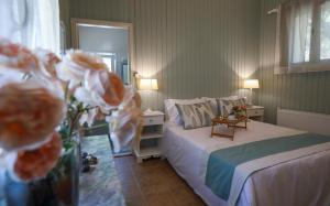アルゴストリオンにあるLiostasi Maison Provencaleのベッドルーム1室(ベッド1台、テーブル、花付)