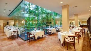 a restaurant with tables and chairs and a large window at Hipotels Natura Palace Adults Only in Playa Blanca