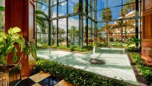 an indoor garden with a hot tub in a glass building at Hipotels Natura Palace Adults Only in Playa Blanca