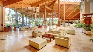 a lobby with couches and tables in a building at Hipotels Natura Palace Adults Only in Playa Blanca