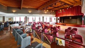 a large room with red chairs and a stage at Hipotels Natura Palace Adults Only in Playa Blanca