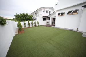 a backyard with a green lawn at Come Inn Homestay 1379 in Miri