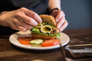 a person is making a sandwich on a plate at GreenStar Hotel Joensuu in Joensuu