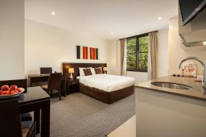 ein Hotelzimmer mit einem Bett, einem Schreibtisch und einer Küche in der Unterkunft Quest Canberra in Canberra