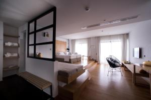 a bedroom with a bed and a desk and a chair at Sunday Boutique Hotel in Nea Stira
