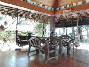 a wooden table and chairs in a room at Fisherman's Hut , ขนำชาวเลโฮมสเตย์ in Pak Meng