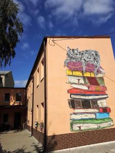 Mural kota na stercie książek w obiekcie Sweetdream Hostel w Charkowie