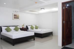 Habitación con 2 camas y sofá en Abeth's Haven en Puerto Princesa