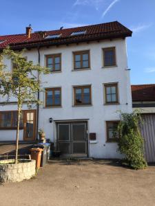 a white house with a tree in front of it at Boardinghouse Schnaitheim in Heidenheim