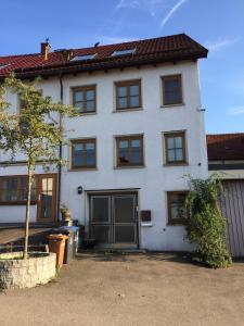 a white house with a tree in front of it at Boardinghouse Schnaitheim in Heidenheim an der Brenz