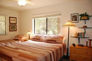 a bedroom with a bed and a window and two lamps at 23A Big Cedar in Wawona