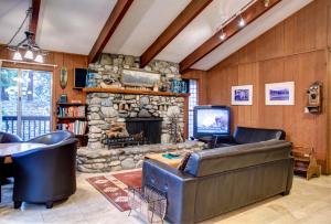 sala de estar con sofá y chimenea de piedra en 12B Star Gazers, en Wawona