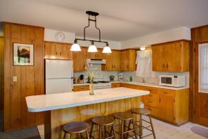 a kitchen with wooden cabinets and a island with bar stools at 11B Sequoia House in Wawona