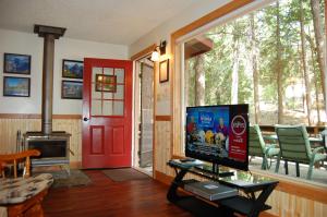 a living room with a tv and a red door at 78 Ox Yoke in Wawona
