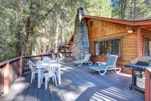 a deck with tables and chairs on a cabin at 55 Deer Creek in Wawona