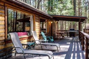 a deck with chairs and tables in the woods at 51 Mia Mora in Wawona