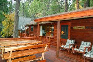 a wooden cabin with two benches on a deck at 8 Nugents Nest in North Wawona