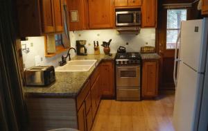 a kitchen with wooden cabinets and a white refrigerator at 6 Squirrels Nest in Wawona