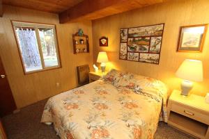 ein Schlafzimmer mit einem Bett, zwei Tischen und einem Fenster in der Unterkunft 6B Meadow View in Wawona