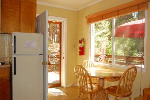 a kitchen with a table and a white refrigerator at 65 Sparrows Nest in Wawona