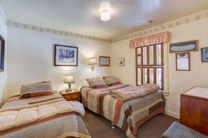 a bedroom with two beds and a window at 80 Chattertons Cottage in North Wawona
