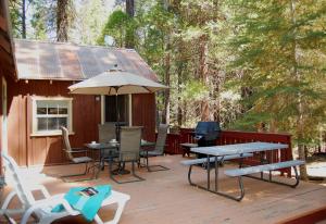 a deck with a table and chairs and an umbrella at 6S Fretzs Den in South Wawona