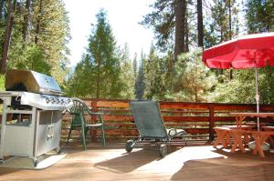 a grill and a chair on a deck with a table at 65 Sparrows Nest in Wawona